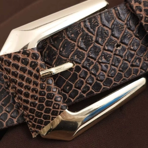Macro detail of dark brown faux animal skin belt texture with gold geometric buckle