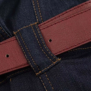 Vue macro détaillée du tissu denim bleu foncé avec les détails de la ceinture en cuir brun