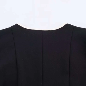 Détail de l'encolure de la mini-robe noire avec bordure blanche contrastée et surpiqûres