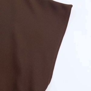 Macro shot of dark brown woven fabric showing high-density texture and clean stitched edge