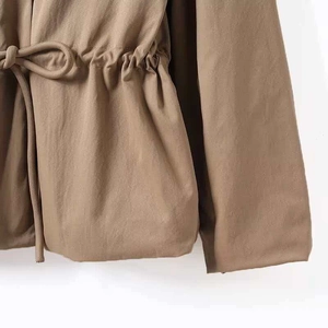 Detailaufnahme des verstellbaren Kordelzugs an der Taille der khakifarbenen Parkajacke