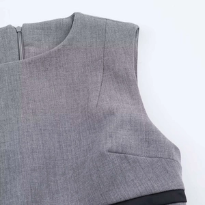 Detail view of gray sleeveless dress featuring a back zipper and black contrast waist trim