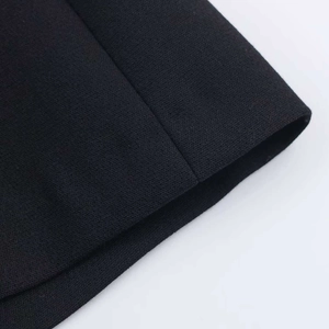 Gros plan détaillé des coutures et du tissu en maille noire sur une mini robe d'été