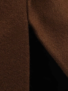 Detail of premium brown wool coat showing high-quality fabric texture and side slit design