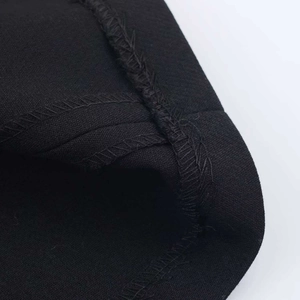 Vue macro du tissu noir mat et détails de couture overlock sur la mini robe d'été