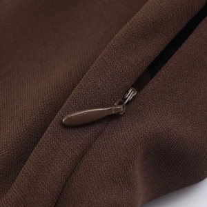 Close-up of the invisible zipper and diagonal twill texture on a brown maxi dress