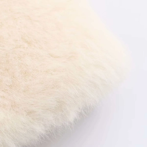 Detailed macro view showing soft cream faux fur texture and long plush fibers of the coat
