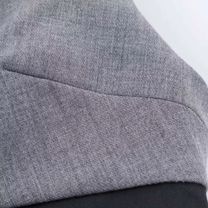 Detail of heather grey fabric texture and black stitching on a sleeveless bow dress