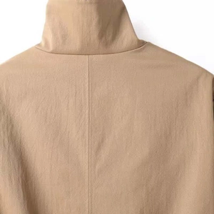 Detailaufnahme einer khakifarbenen Parkajacke mit Stehkragen und präzisen Nähten