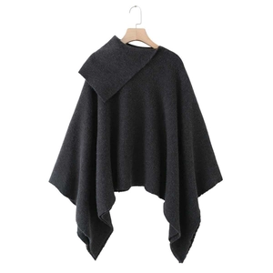 Detailed view of dark grey chunky knit poncho featuring a high turtleneck and asymmetric hem