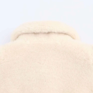 Close-up of beige faux fur coat featuring soft plush texture and elegant lapel collar