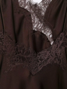 Macro detail of chocolate satin dress with delicate black eyelash lace trim