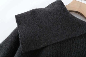 Detail view of dark grey knit poncho top featuring plush texture and wide lapel collar