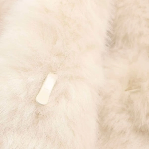 Detail of soft faux fur texture and white hook fastener on a stylish winter coat