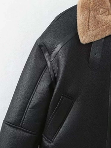 Détail de la veste vintage en similicuir noir avec col contrasté en fausse fourrure brune