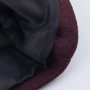 Macro view of burgundy wool blend coat fabric with premium black inner lining details