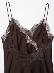 Detail of the V-neckline with delicate eyelash lace trim on a chocolate satin dress