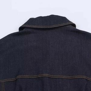 Détail macro d'une robe en jean bleu avec empiècement dos et surpiqûres jaunes