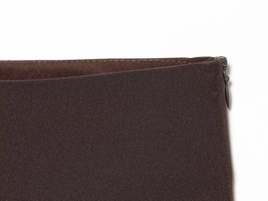Detailed close-up of dark brown asymmetrical skirt featuring a seamless hidden zipper