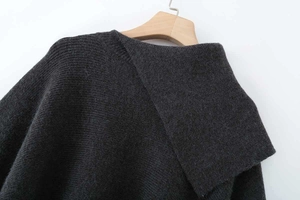 Detail shot of dark grey knit sweater collar with textured vertical ribbing on hanger