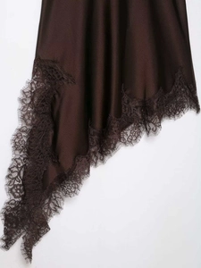 Detail view of smooth dark brown satin dress hem featuring delicate floral eyelash lace trim