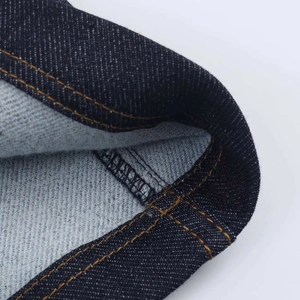 Vue détaillée de la robe en jean avec tissu indigo vintage et coutures orange contrastées