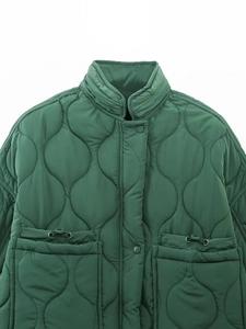 Detailed view of dark green quilted jacket featuring drawstring pockets and stand collar