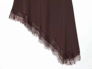 Detail of asymmetrical chocolate skirt hem with delicate eyelash lace trim and smooth finish