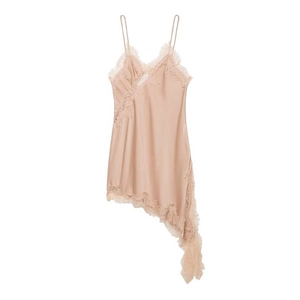 Detail of nude pink satin slip dress featuring delicate eyelash lace trim and asymmetric hem