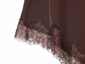 Detailed view of chocolate brown satin fabric with delicate eyelash lace trim detail