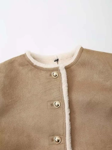 Détail d'une veste en daim beige avec doublure en fausse fourrure et boutons dorés
