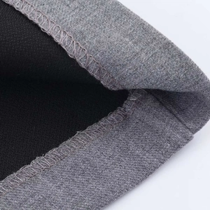 Close-up of grey knitted fabric with black fleece lining and durable overlock stitching