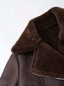 Close-up of the vintage shearling collar and metallic zipper on a brown biker jacket