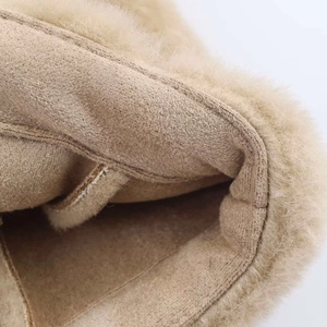 Detailed macro view of beige faux shearling lining and knitted texture on a warm vest