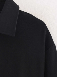 Macro detail of black cropped jacket collar showing twill texture and stitching