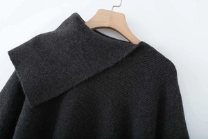 Detailed view of dark grey chunky knit sweater featuring a wide fold-over turtleneck collar