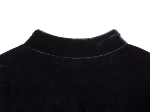 Dettaglio del collo alto di un abito in velluto nero con cuciture di alta qualità