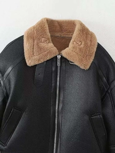 Détail de la veste biker en simili cuir noir avec col en fourrure brune et fermeture éclair