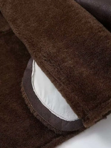 Macro detail of brown faux shearling jacket with premium leather trim and warm lining