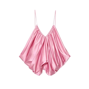 Detail view of pink satin camisole featuring deep V-neck and ruffled hemline