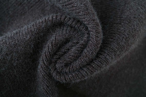 Macro detail of soft coffee brown ribbed knit fabric with fluffy wool texture