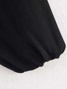 Macro shot of pleated elastic cuffs and twill fabric texture on a black cropped jacket