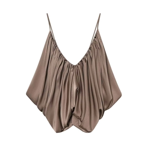 Detailed view of champagne satin camisole showing the draped deep V-neck and silky texture