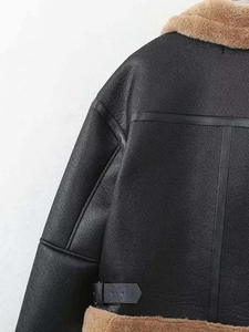 Détail d'une veste vintage en cuir noir avec col en fourrure marron et boucle réglable