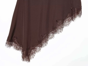 Detail of dark brown skirt with asymmetric hem and delicate eyelash lace trim decoration