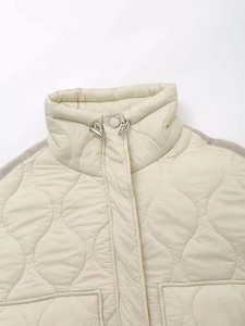 Detail of beige quilted jacket featuring a high stand collar and adjustable drawstring