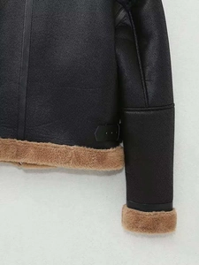 Détail de la texture en similicuir noir avec doublure en fourrure marron sur la veste d'hiver