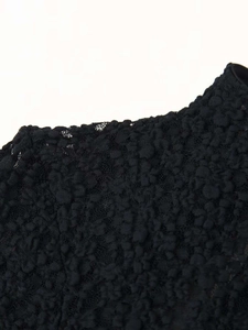 Macro shot of black lace fabric with dense floral patterns and crochet textures