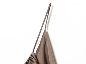 Close-up of brown satin camisole featuring delicate pleats and thin shoulder straps