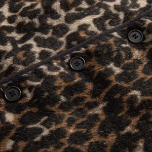 Close-up of leopard print vest showing plush texture and textured black buttons detail